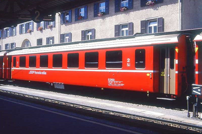 RhB - B 2450 am 31.08.1993 in St.Moritz - 2.Klasse Einheitspersonenwagen (Typ II) - bernahme 08.12.1980 - FFA/SWP - Fahrzeuggewicht 15,00t - Sitzpltze 52 - LP 18,50m - zulssige Geschwindigkeit 90 km/h - 2=01.02.1989 - Logo RhB in italienisch - gelbe Hinweispfeile auf Tren fr Taster neben den Tren - Kennzeichnung an den Ecken gelb - Hinweis: Die Fahrzeugserie besteht aus 30 Wagen mit den Nummern 2421 bis 2450. 
