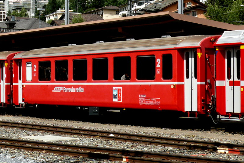 RhB - B 2451 am 25.07.2010 in St.Moritz - 2.Klasse verkrzter Einheitspersonenwagen (Typ II) fr Berninabahn  - Baujahr 1972 - FFA/SWP - Fahrzeuggewicht 14,00t - Sitzpltze 50 - LP 14,90m - zulssige Geschwindigkeit 90 km/h - Logo RhB in italienisch - Hinweis: Die Fahrzeugserie bestand aus 10 Wagen mit den Nummern 2451 bis 2460. 
