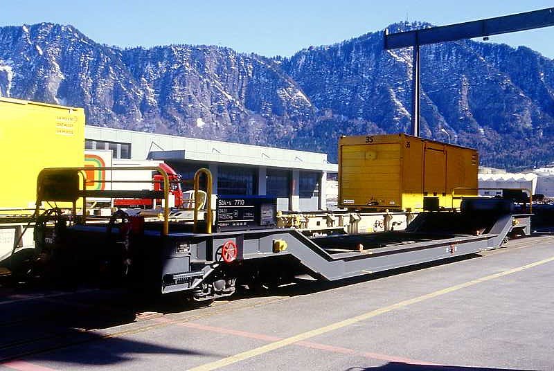 RhB - Sbk-v 7710 am 27.02.2000 in Landquart Ried - Tiefladewagen mit Post-Container 4-achsig mit 1 offenen Plattform - bernahme 03.06.1999 - JMR - Gewicht 14,36t - Zuladung 24,00t - LP 15,94m - zulssige Geschwindigkeit 90 km/h - Die Fahrzeugserie bestand aus 15 Wagen mit den Numern 7701 bis 7715
